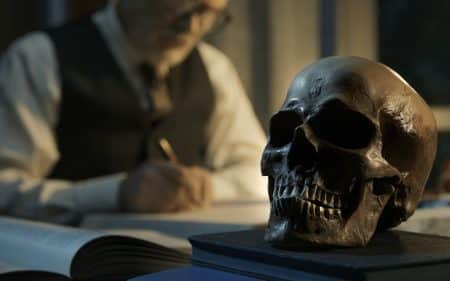 A professor studying a human skull