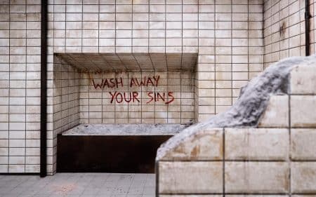 Wash your sins away written in blood on a wall at SAW: The experience