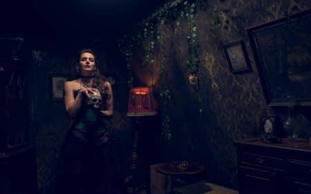 Lady Chastity holding a skull in her lair at Houdini's