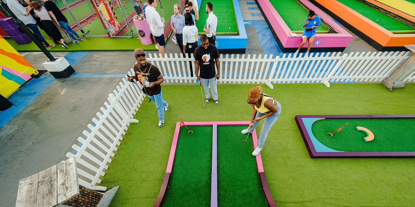 Friends playing mini golf at Birdies on Roof East