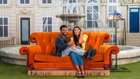 A couple on the iconic orange sofa at The Friends Experience