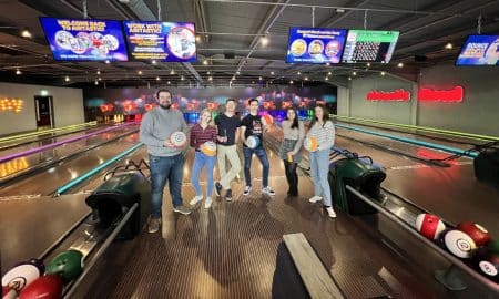 Friends posing with bowling balls at the bowling lanes at Airtastic in Lisburn